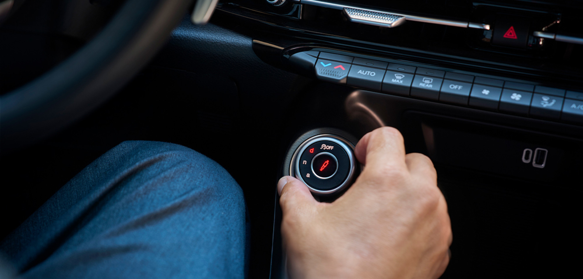 Intérieur d'un Alfa Romeo Tonale à essence 2026 présentant le sélecteur de mode de conduite DNA, avec une main ajustant la commande, mettant en évidence les fonctionnalités de personnalisation et d'expérience de conduite.