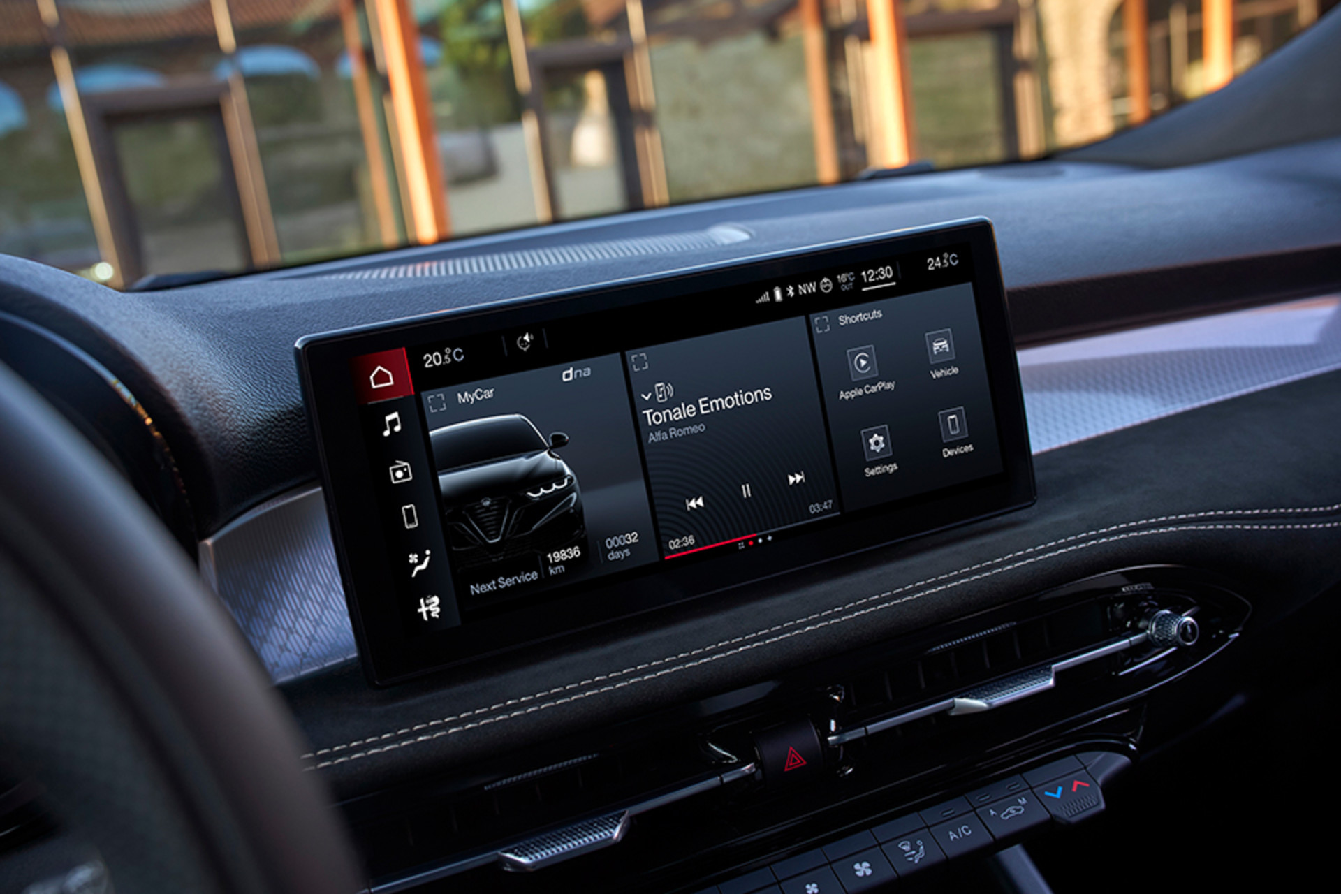 Intérieur d'un Alfa Romeo Tonale à essence 2026 avec un grand écran d'infodivertissement intégrant les commandes musicales et du véhicule, le tout sur un tableau de bord au design élégant.