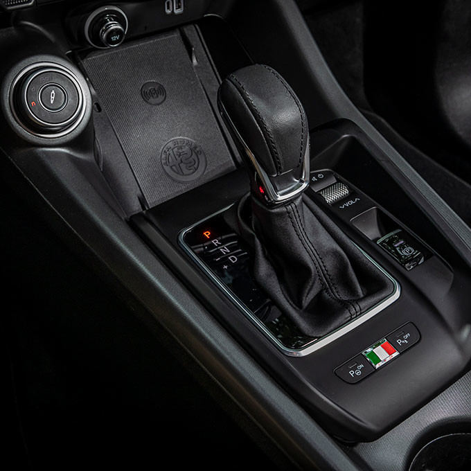 Interior view of a 2025 Alfa Romeo Tonale PHEV showcasing the gear shifter, the drive mode selector  and the console area.
