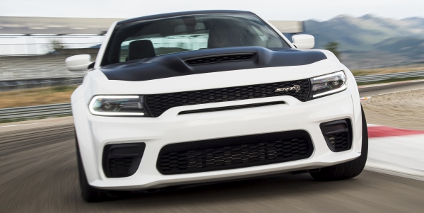 Vue de face d'un Dodge Charger 2021 blanc roulant à grande vitesse sur une route.