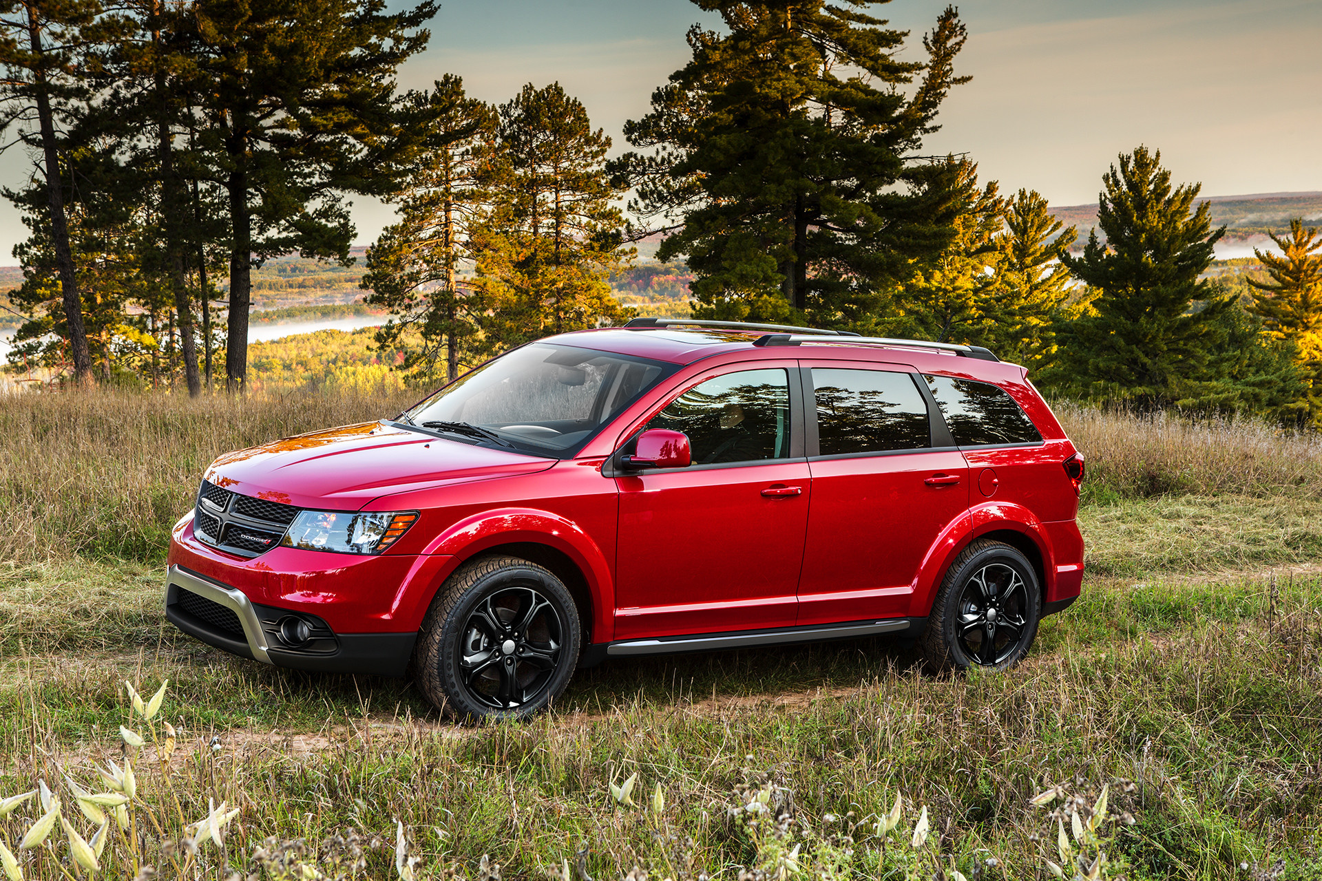 Side view of the red 2020 Dodge Journey driving through a field