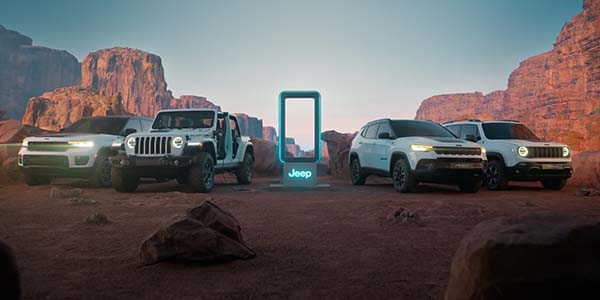 A packshot of the Jeep 4xe lineup around a Jeep charging station.