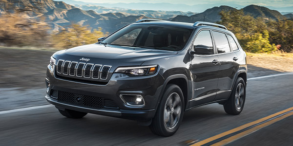2022 Cherokee Limited in Granite Crystal, driving on an urban highway.