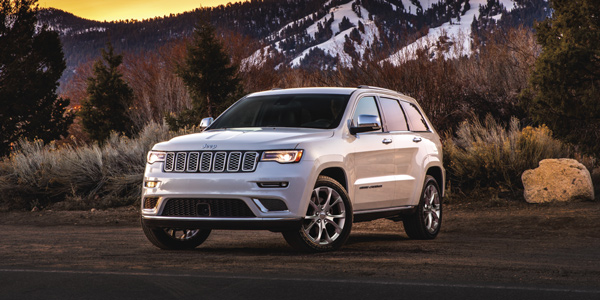 White 2020 Jeep Grand Cherokee parked on the side of the road at sunset