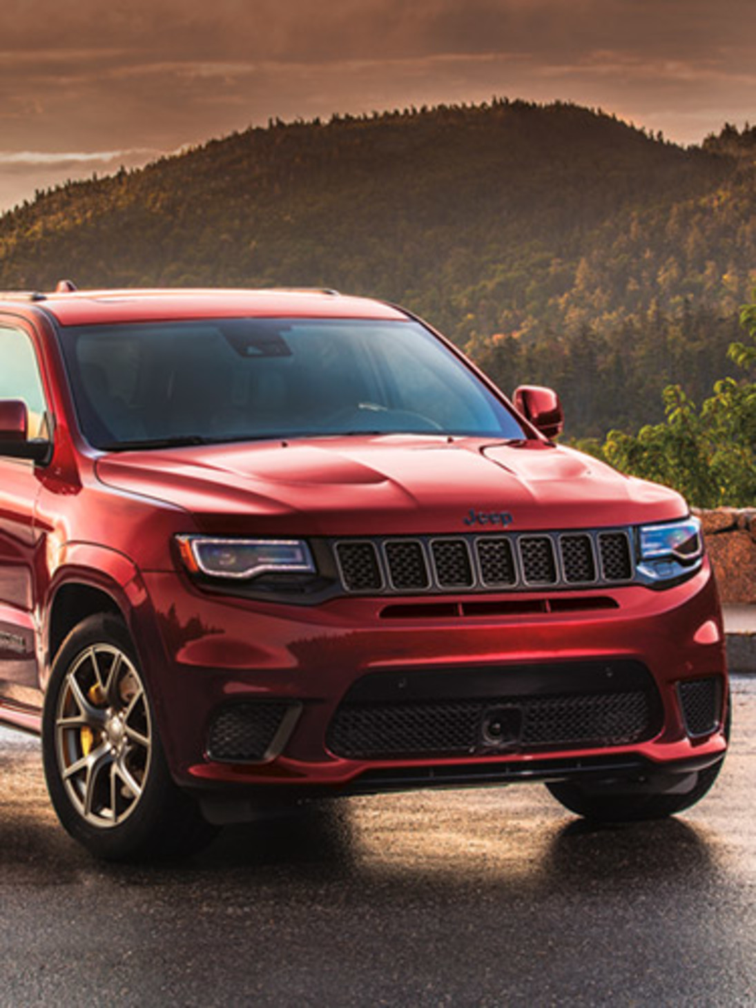 Front quarter view of a red  2021 Grand Cherokee Trackhawk parked on a road