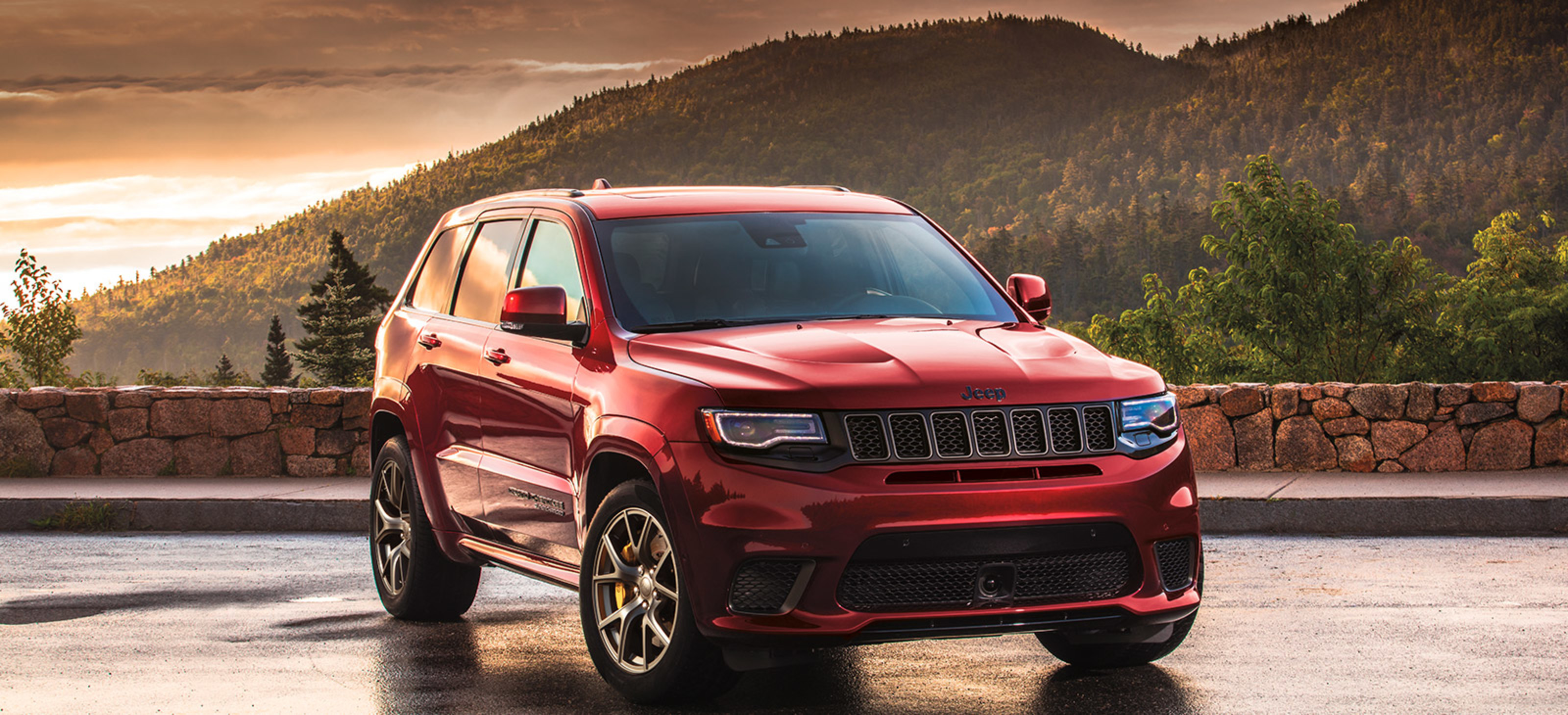Front quarter view of a red  2021 Grand Cherokee Trackhawk parked on a road
