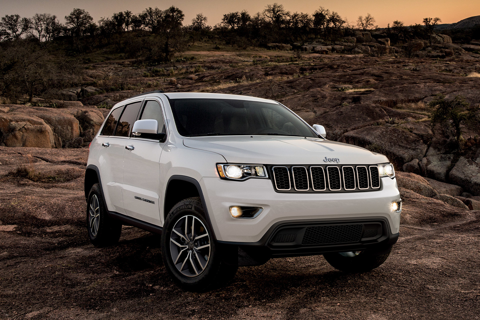 2022 Grand Cherokee WK Laredo in Bright White parked on a rocky cliff with lights on