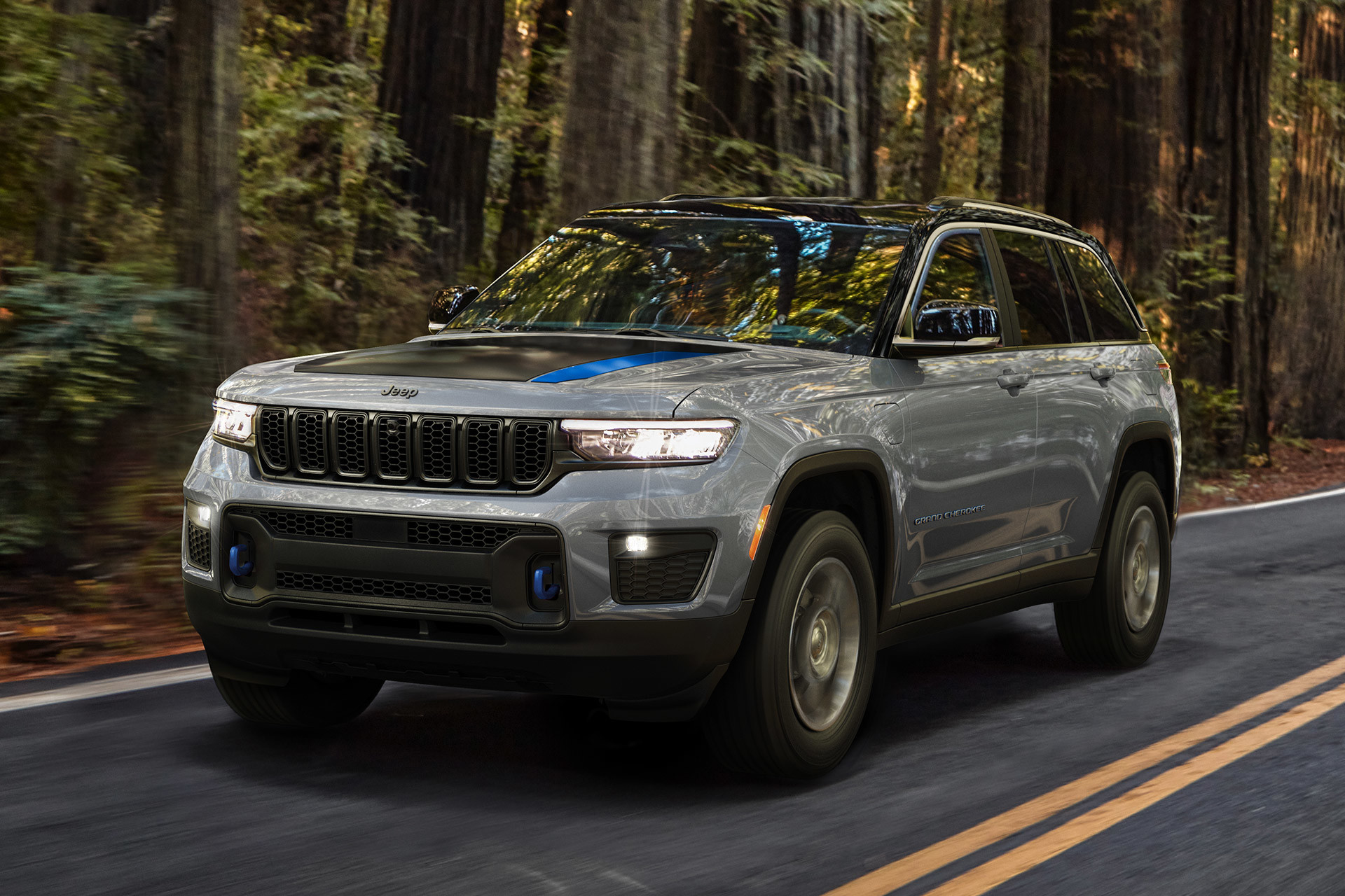 Front view of an All-New 2022 Jeep Grand Cherokee 4xe being driven down a forest road.