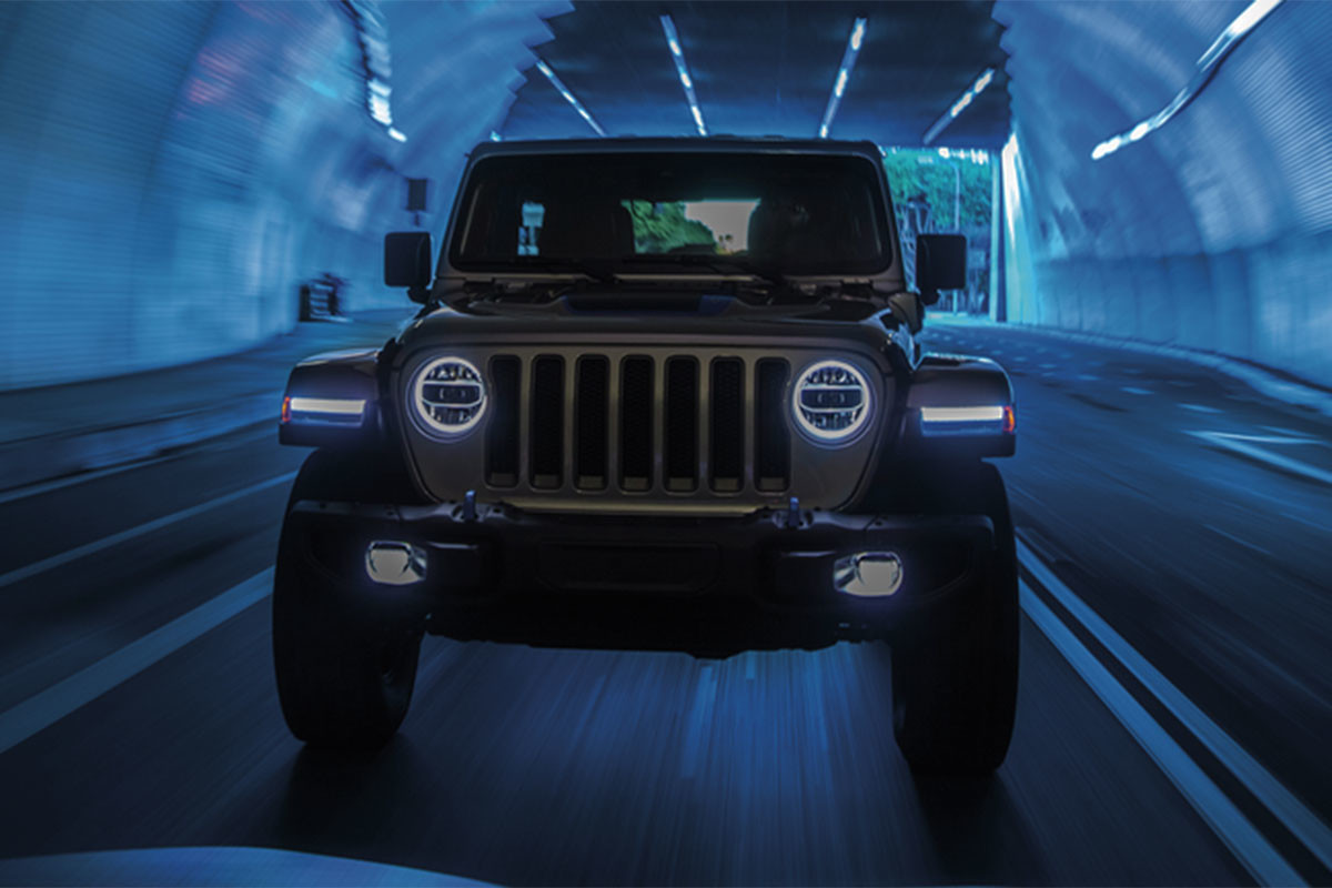 A front view of a 2024 Jeep Wrangler 4xe driving in a tunnel.