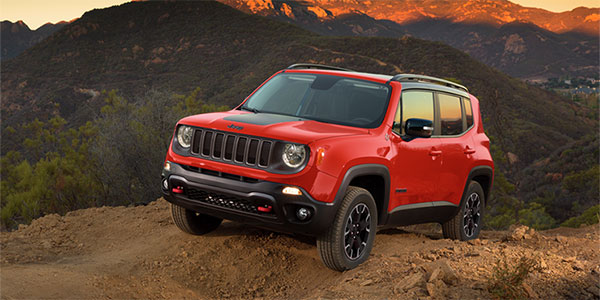 Un Renegade rouge garé au sommet d'une montagne.
