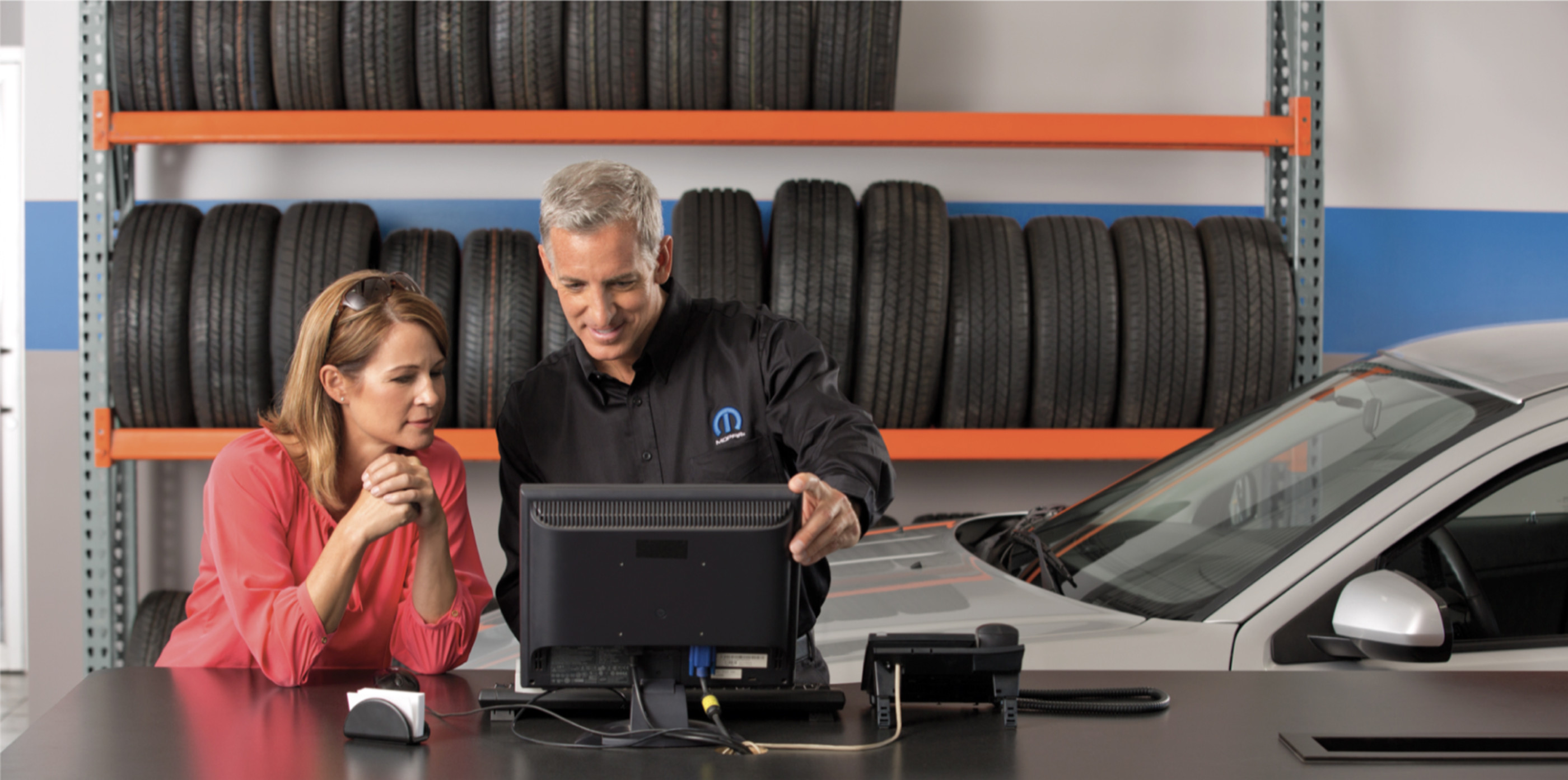 View of a service professional explaining the tire guide to a customer.