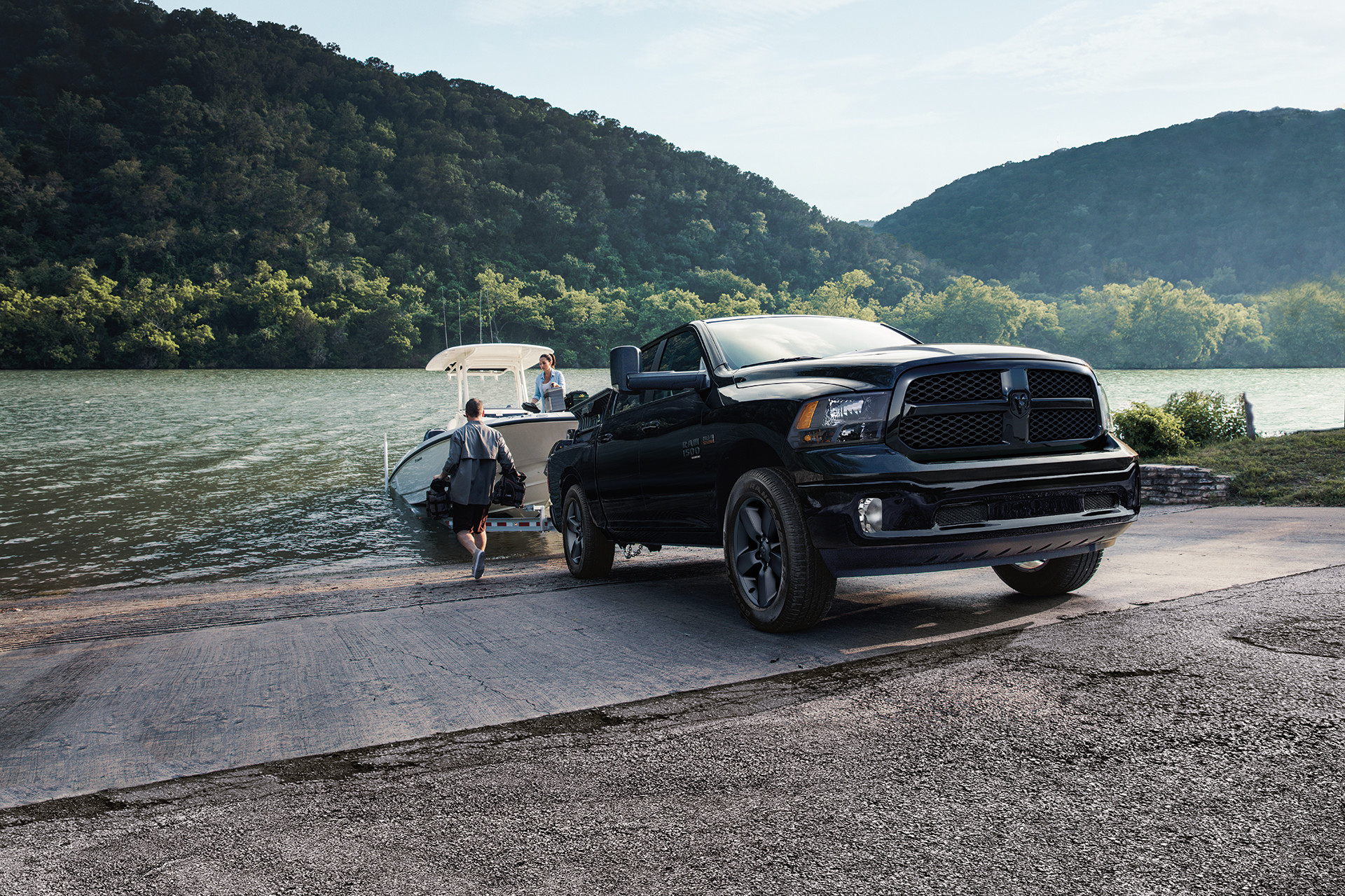 A black 2022 Ram 1500 Classic towing a boat out of water. 