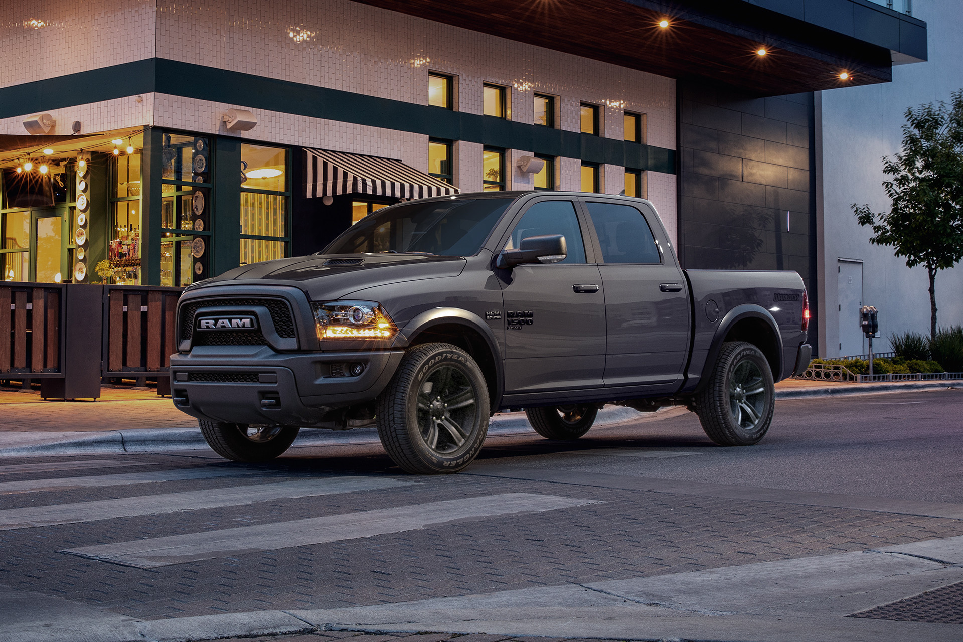 A grey 2022 Ram 1500 Classic, stopped on a road with buildings in the background.