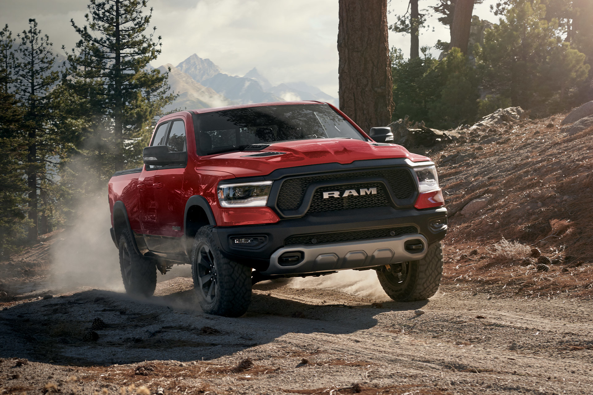 Red 2022 Ram 1500 driving off road through a forest