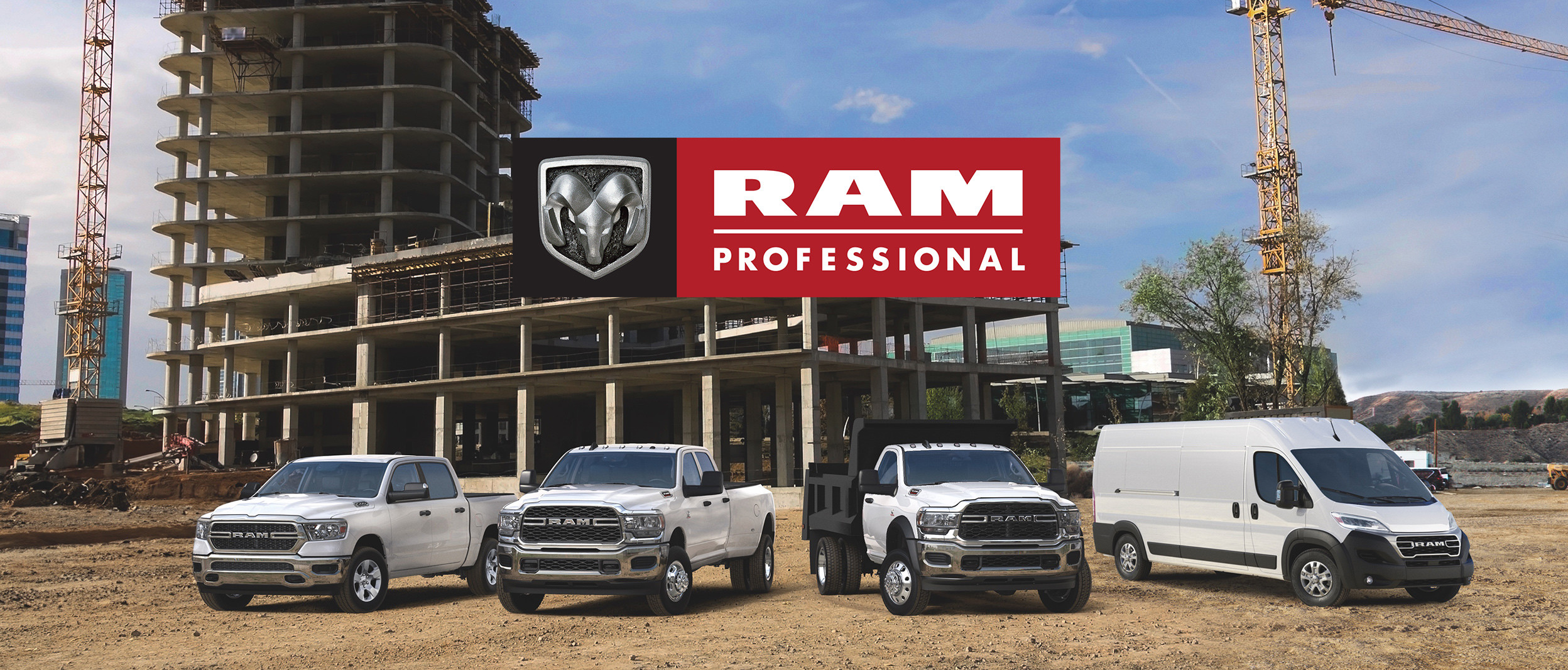 A fleet of Ram Professional pickup trucks lined up beside each other while parked outside on gravel terrain overlooking a construction site.