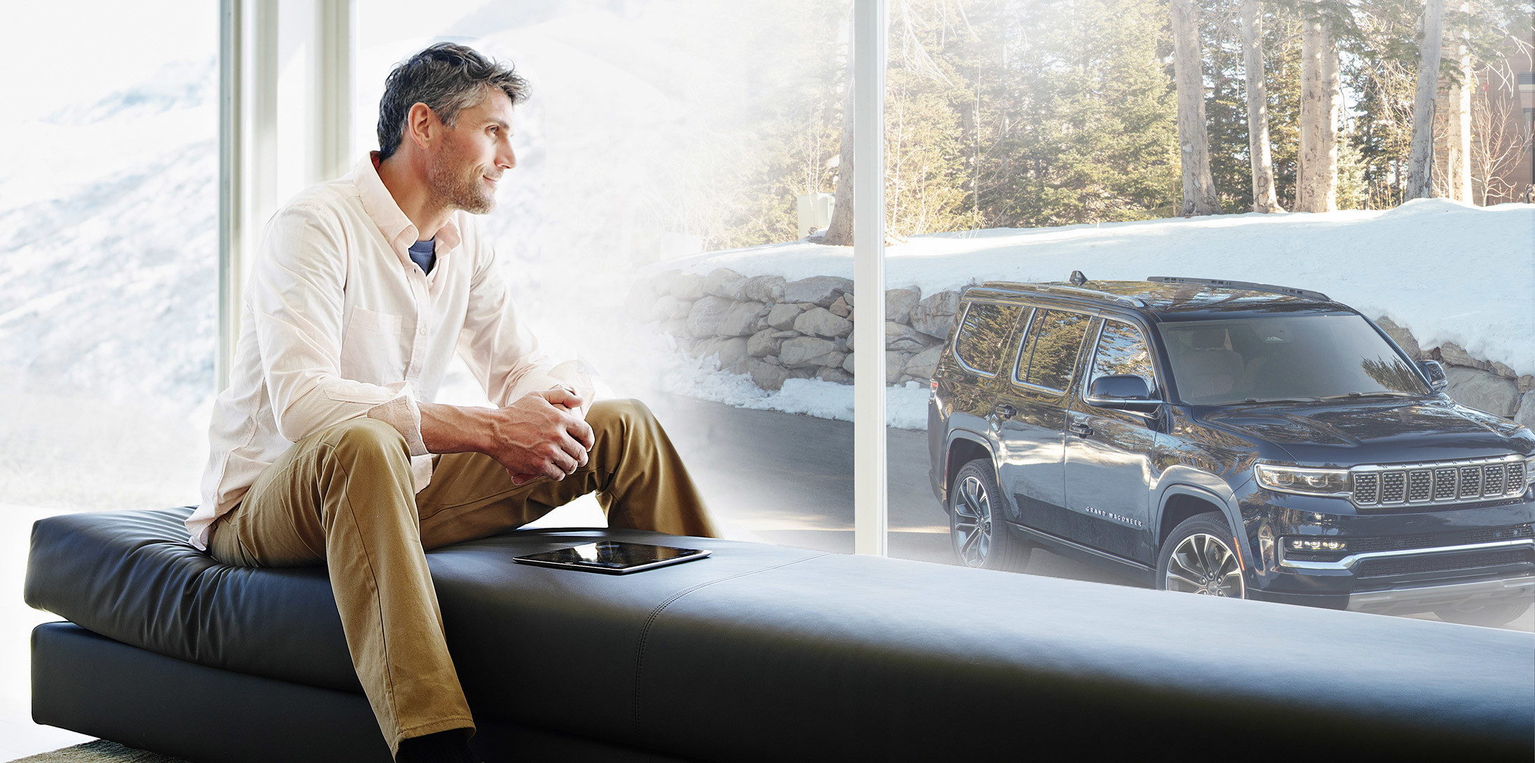 Man gazing out the window looking at blue Grand Wagoneer.