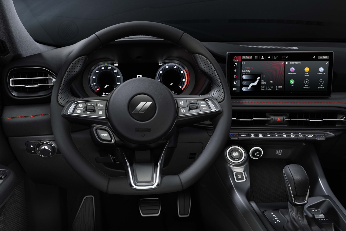 Dodge Hornet interior with performance steering wheel, digital driver cluster, and advanced touchscreen display, at Tuttle-Click Dodge in Tustin.