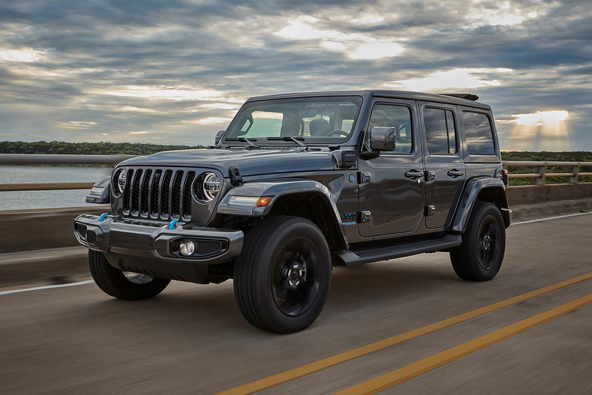 Grey 2022 Jeep Wrangler 4xe driving down a highway. 